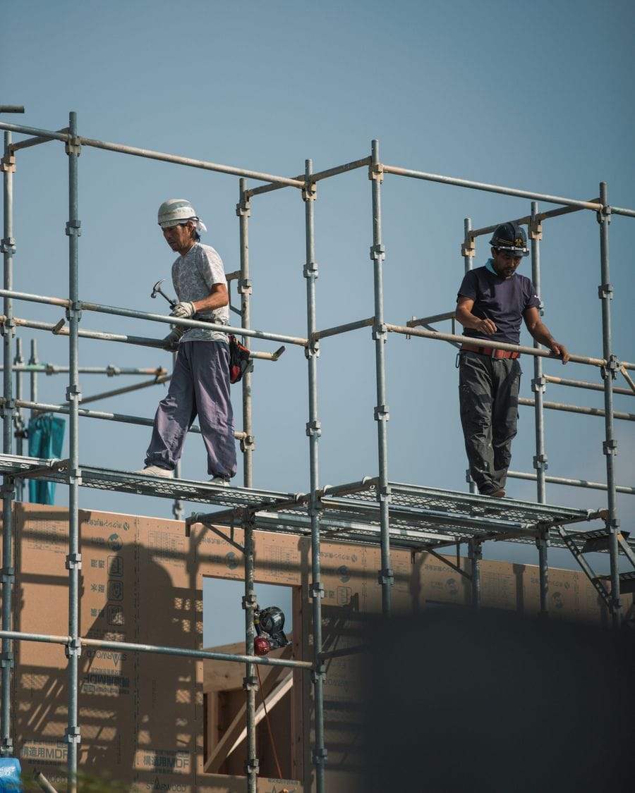 Two scaffold erectors working on a steel scaffold frame